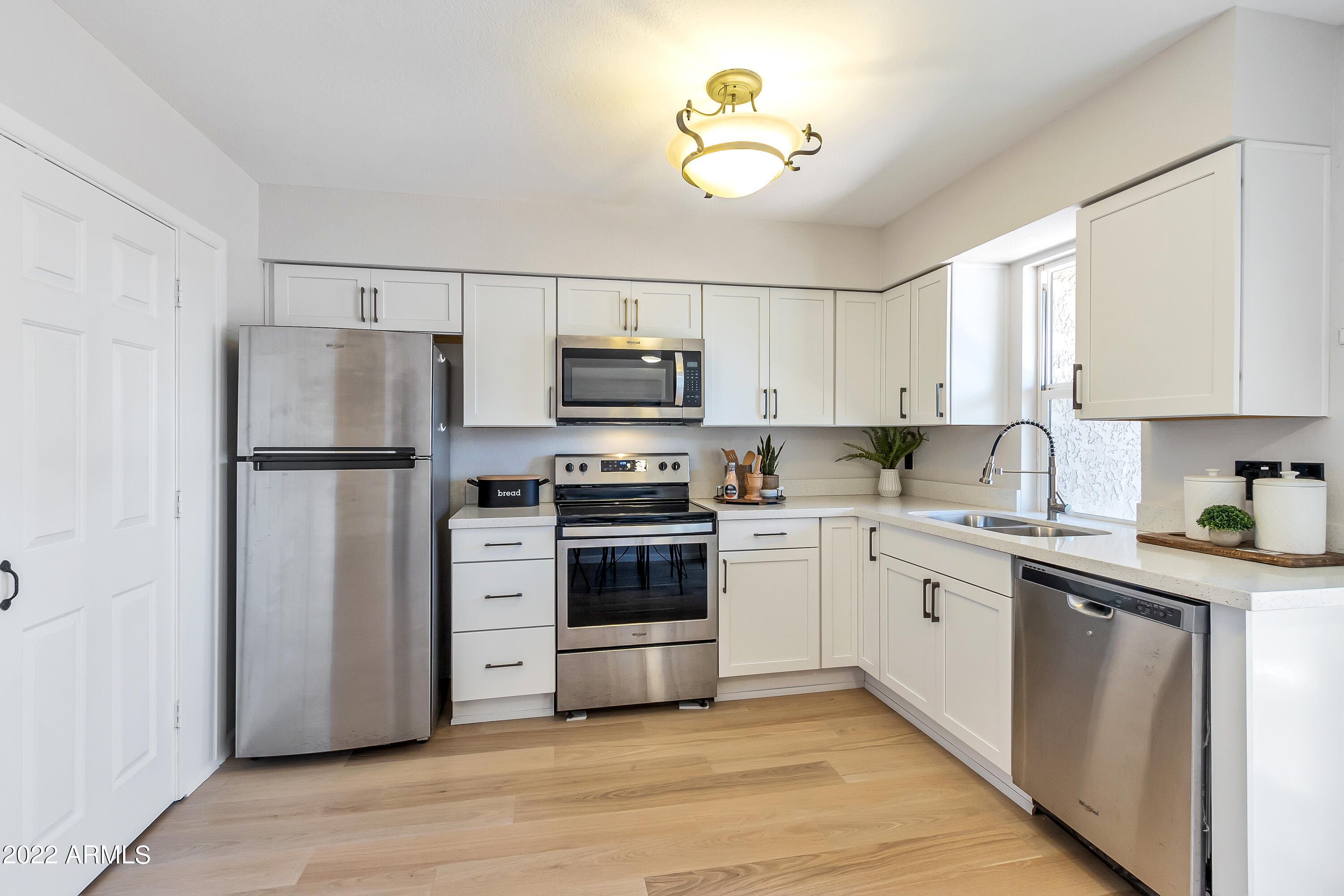 6348 North 7th Avenue, Unit 12 Phoenix, AZ 85013 - Photo 7 of 22 a kitchen with stainless steel appliances a refrigerator sink and microwave