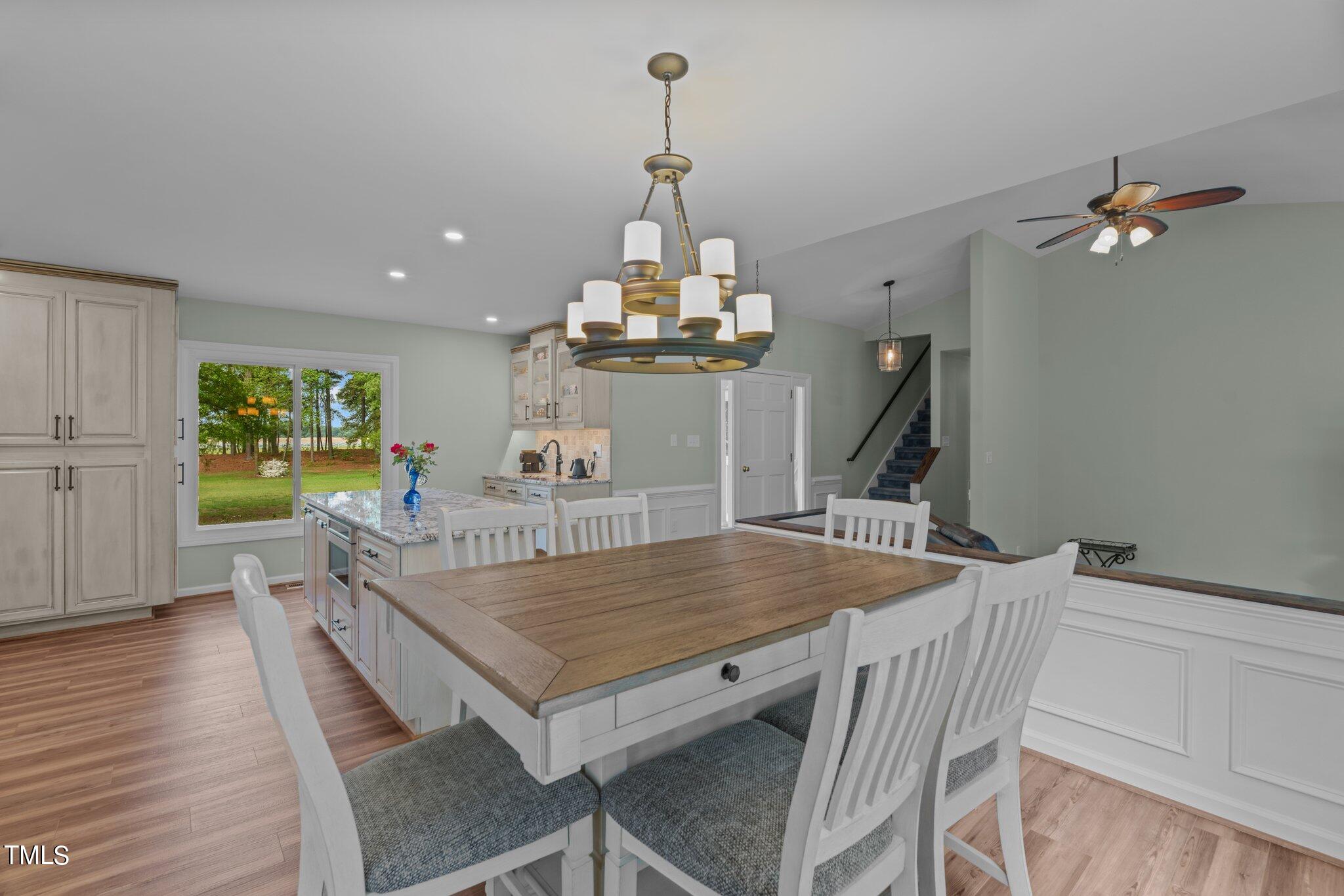744 Alderman Mill Road Dunn, NC 28334 - Photo 11 of 50 a dining room with wooden floor a chandelier a wooden table and chairs