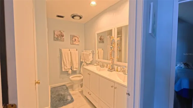 a bathroom with a sink mirror vanity and toilet
