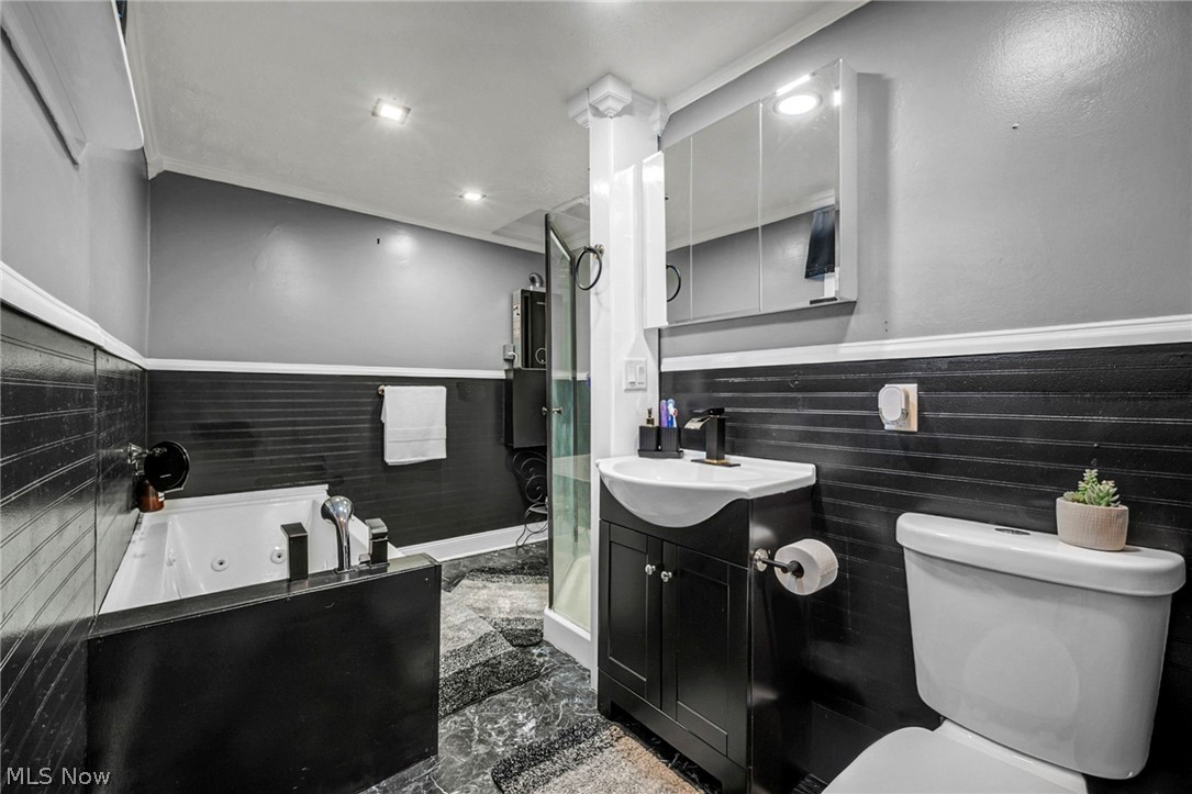 4717 Snow Road Cleveland, OH 44134 - Photo 15 of 30 Full bathroom with a whirlpool tub, vanity, a wainscoted wall, a stall shower, and recessed lighting