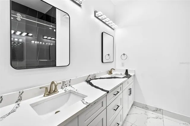 a bathroom with a double vanity sink mirror and shower