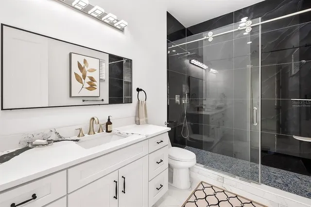 a bathroom with a sink a toilet and shower