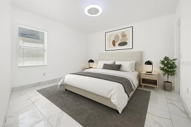a bedroom with bed and a potted plant