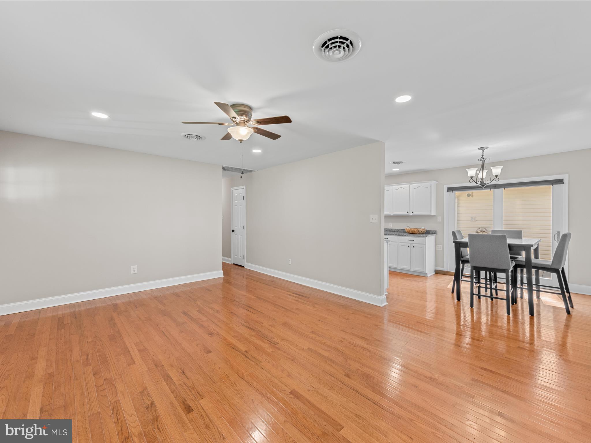 26831 River Road Seaford, DE 19973 - Photo 15 of 41 an empty room with wooden floor and way to kitchen