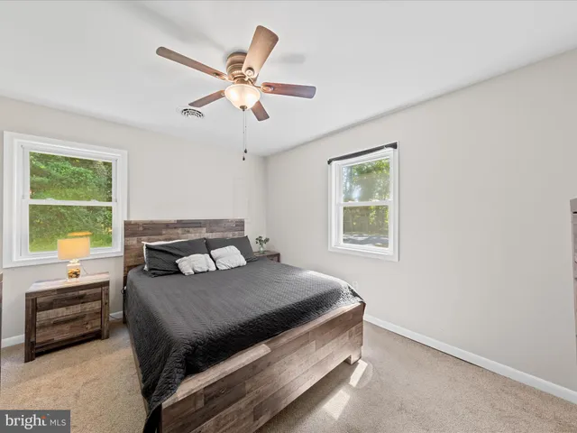 a view of a room with wooden floor and ceiling fan