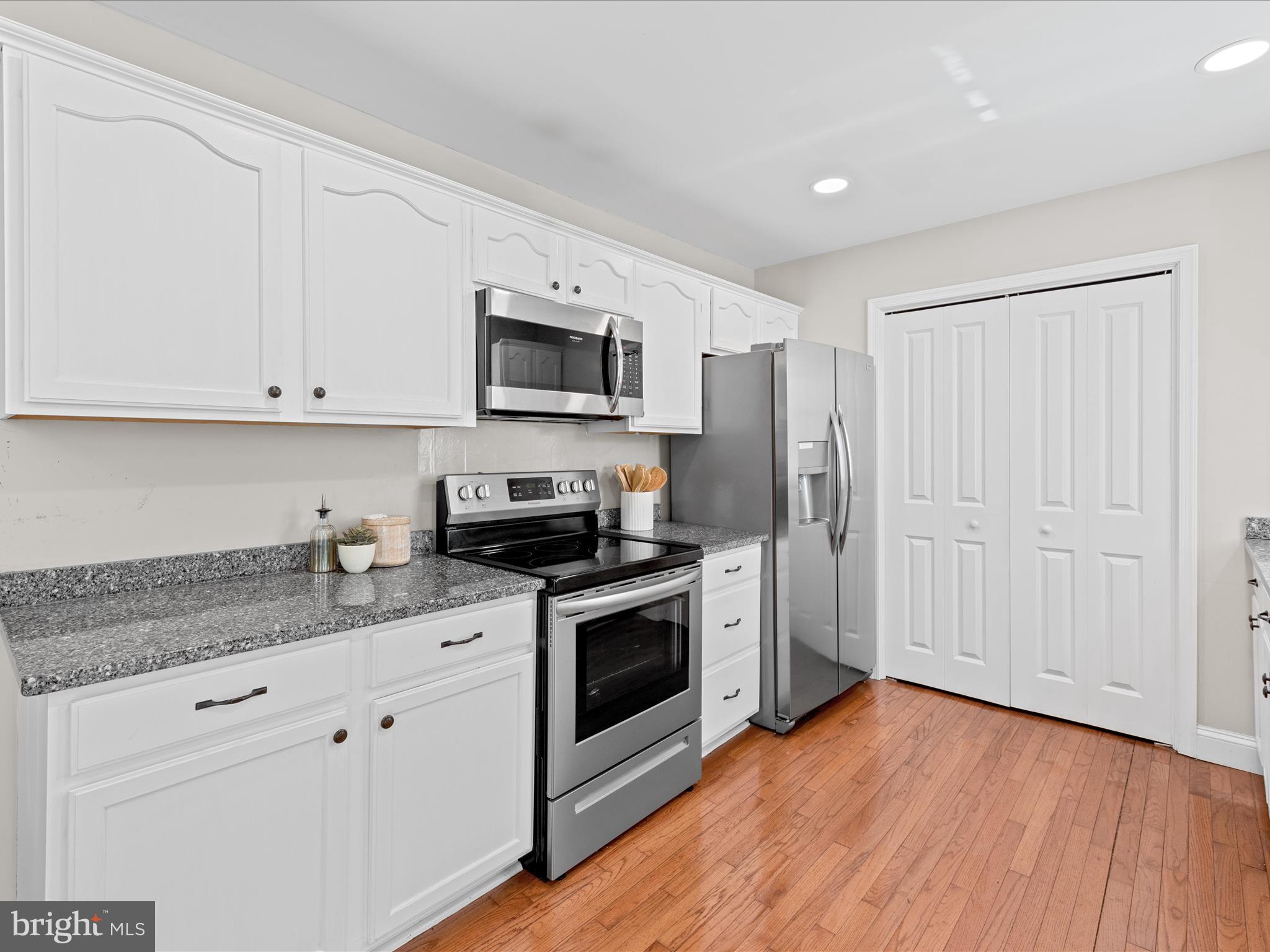 26831 River Road Seaford, DE 19973 - Photo 4 of 41 a kitchen with granite countertop white cabinets stainless steel appliances and wooden floor