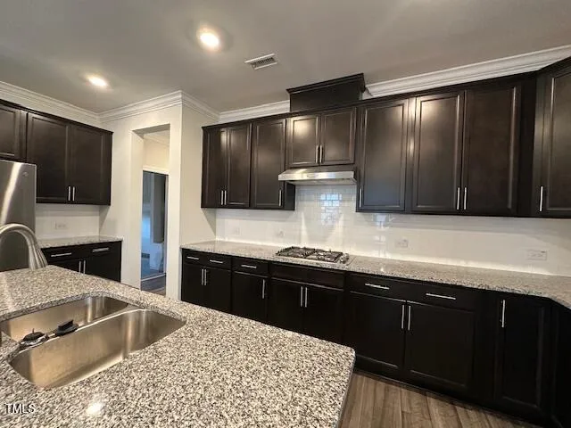 a kitchen with stainless steel appliances granite countertop a sink stove and refrigerator