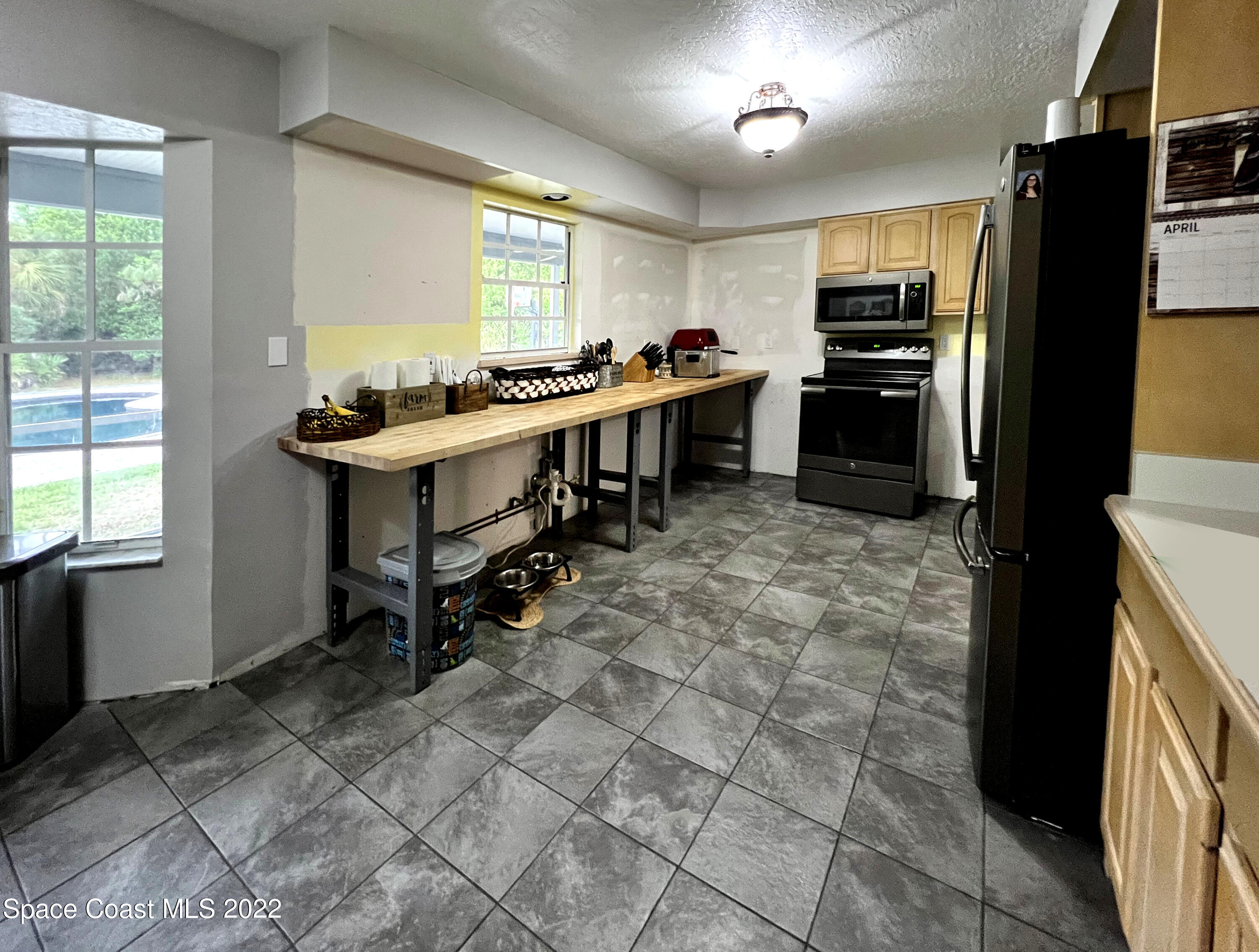 4030 Sparrow Hawk Road Melbourne, FL 32934 - Photo 23 of 46 a kitchen with stainless steel appliances a stove refrigerator sink and cabinets