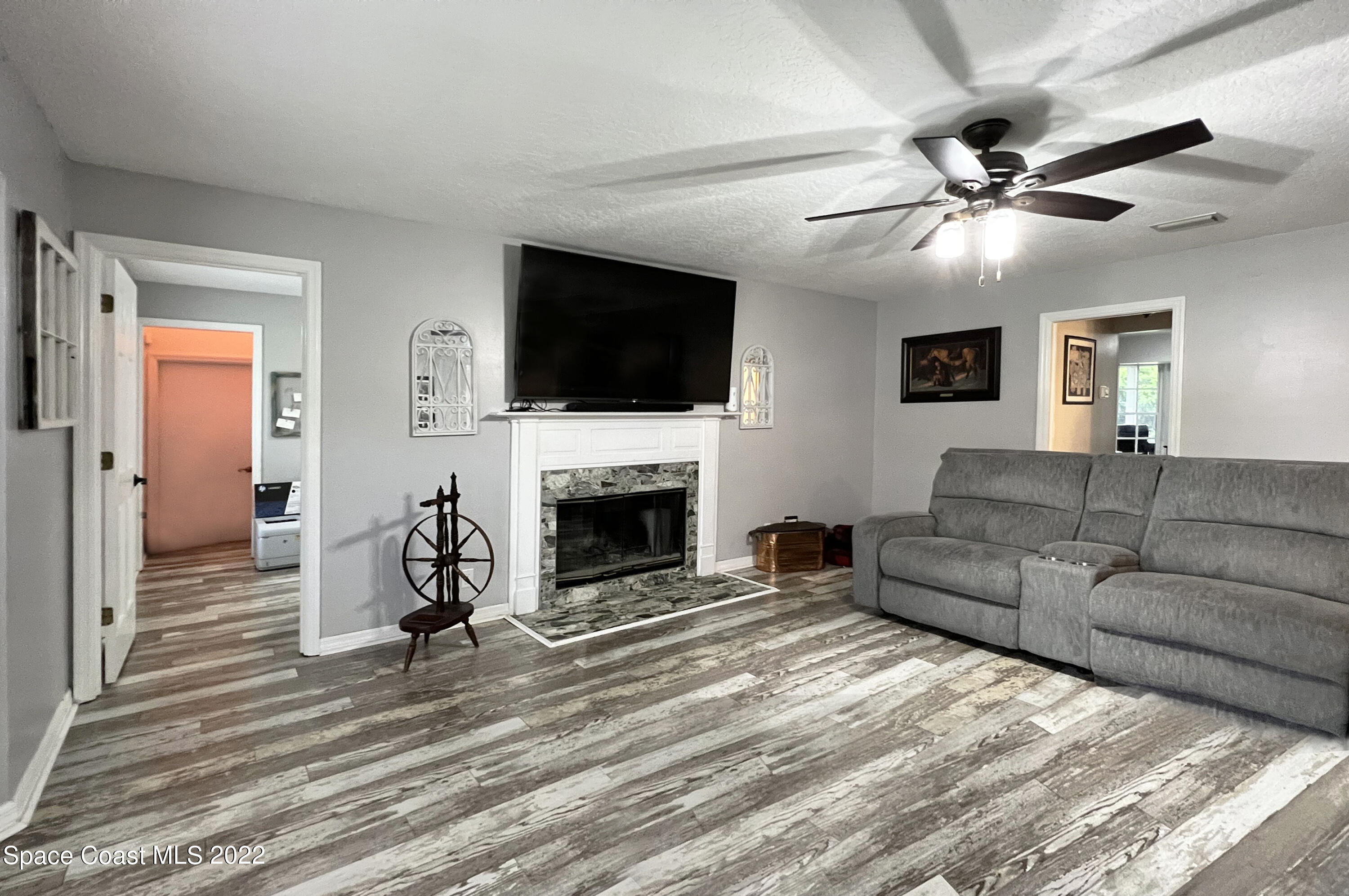 4030 Sparrow Hawk Road Melbourne, FL 32934 - Photo 28 of 46 a living room with furniture a fireplace and a flat screen tv