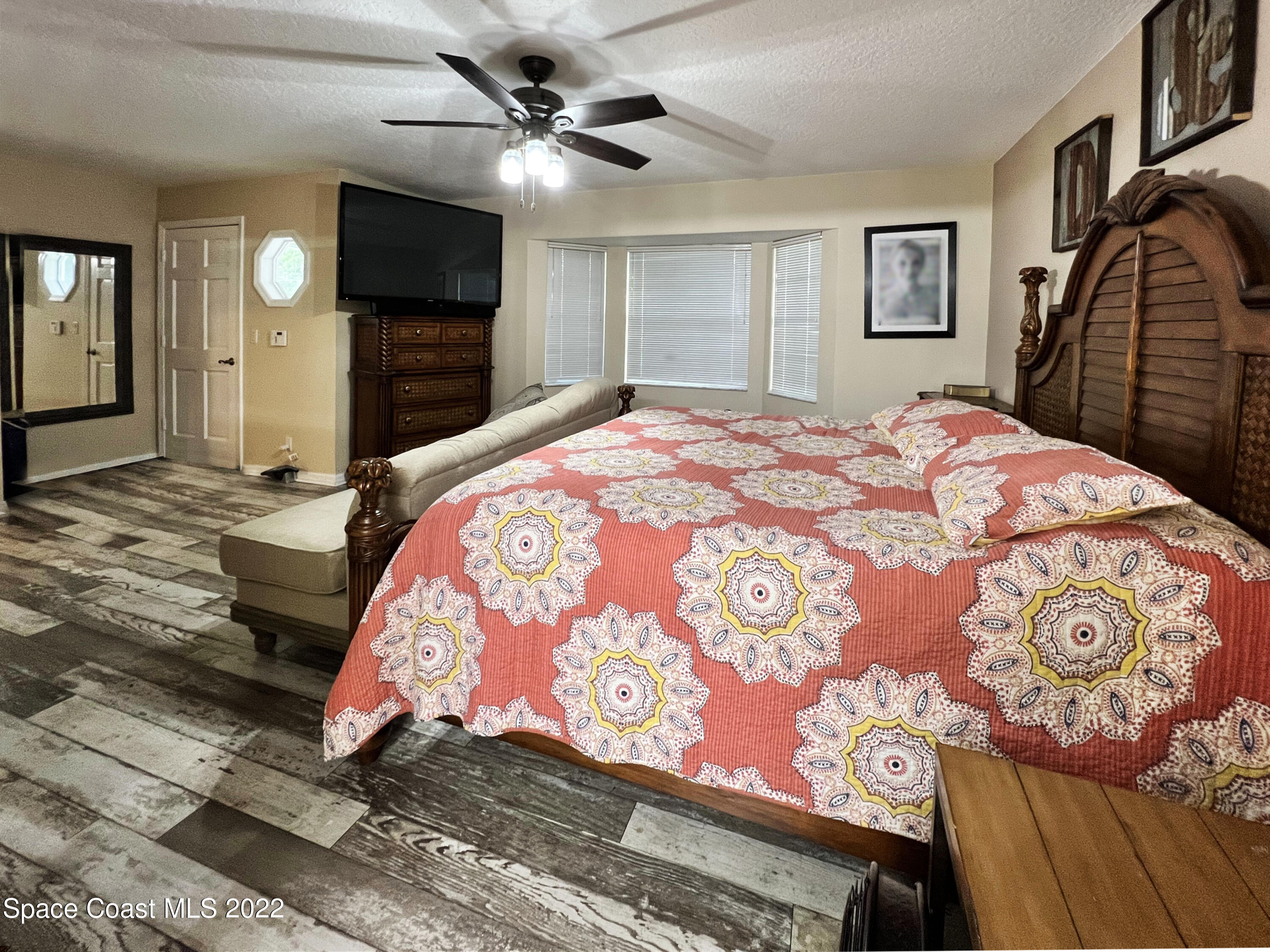 4030 Sparrow Hawk Road Melbourne, FL 32934 - Photo 29 of 46 a bedroom with a large bed and a flat screen tv