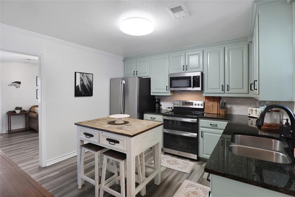 271 East Houston Street Van Alstyne, TX 75495 - Photo 13 of 40 a kitchen with a stove a sink and a refrigerator