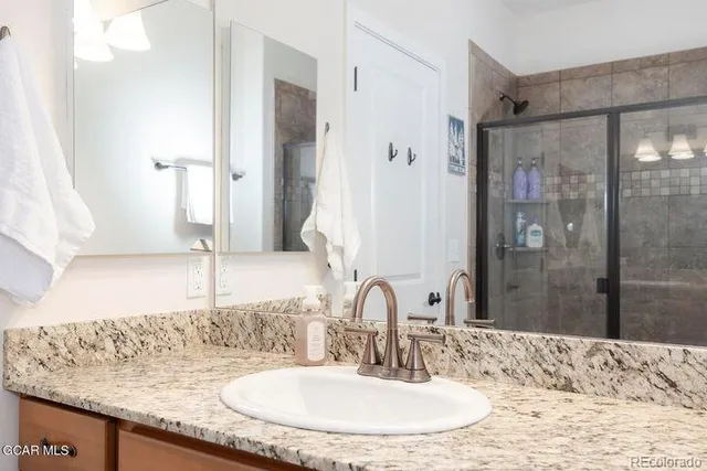 a bathroom with a granite countertop sink and a mirror