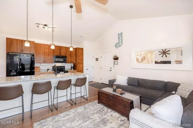 a living room with furniture a flat screen tv and kitchen view