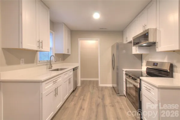 a kitchen with stainless steel appliances a sink stove refrigerator and cabinets