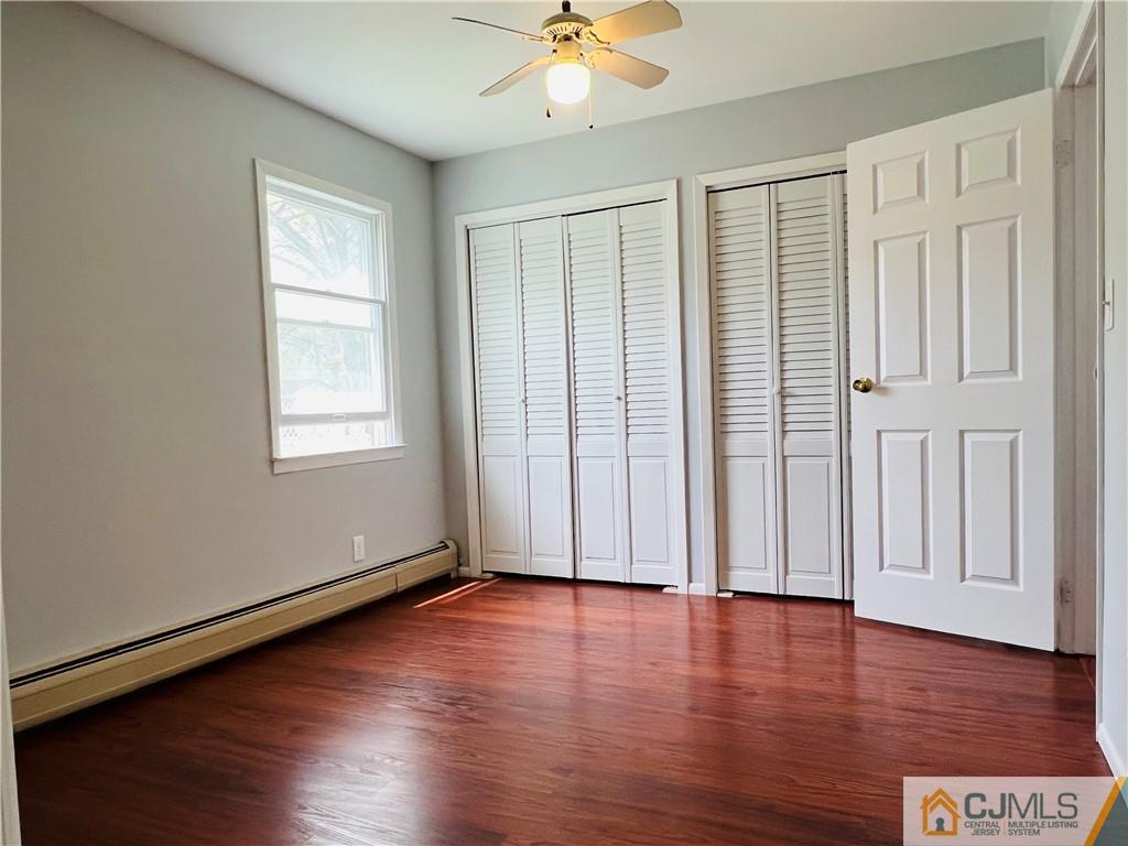 55 Glenville Road Edison, NJ 08817 - Photo 20 of 28 an empty room with wooden floor chandelier fan and windows
