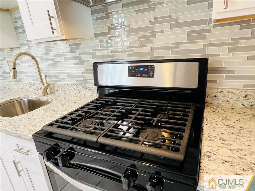 55 Glenville Road Edison, NJ 08817 - Photo 10 of 28 a close view of a stove a microwave oven and a sink in the kitchen