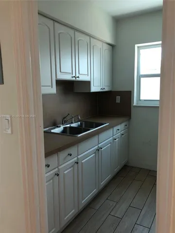a kitchen with stainless steel appliances granite countertop a sink and cabinets with wooden floor