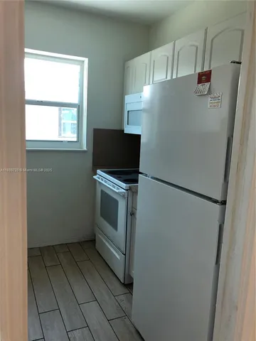 a white refrigerator freezer and a stove sitting inside of a kitchen