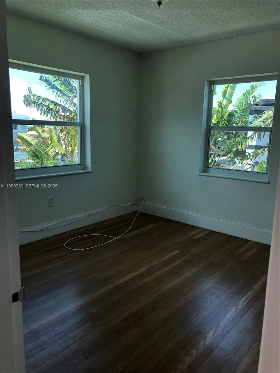 2320 Northwest 15th Street Miami, FL 33125 - Photo 6 of 7 an empty room with wooden floor and windows