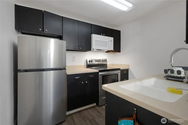 a kitchen with a refrigerator a stove a sink and a microwave