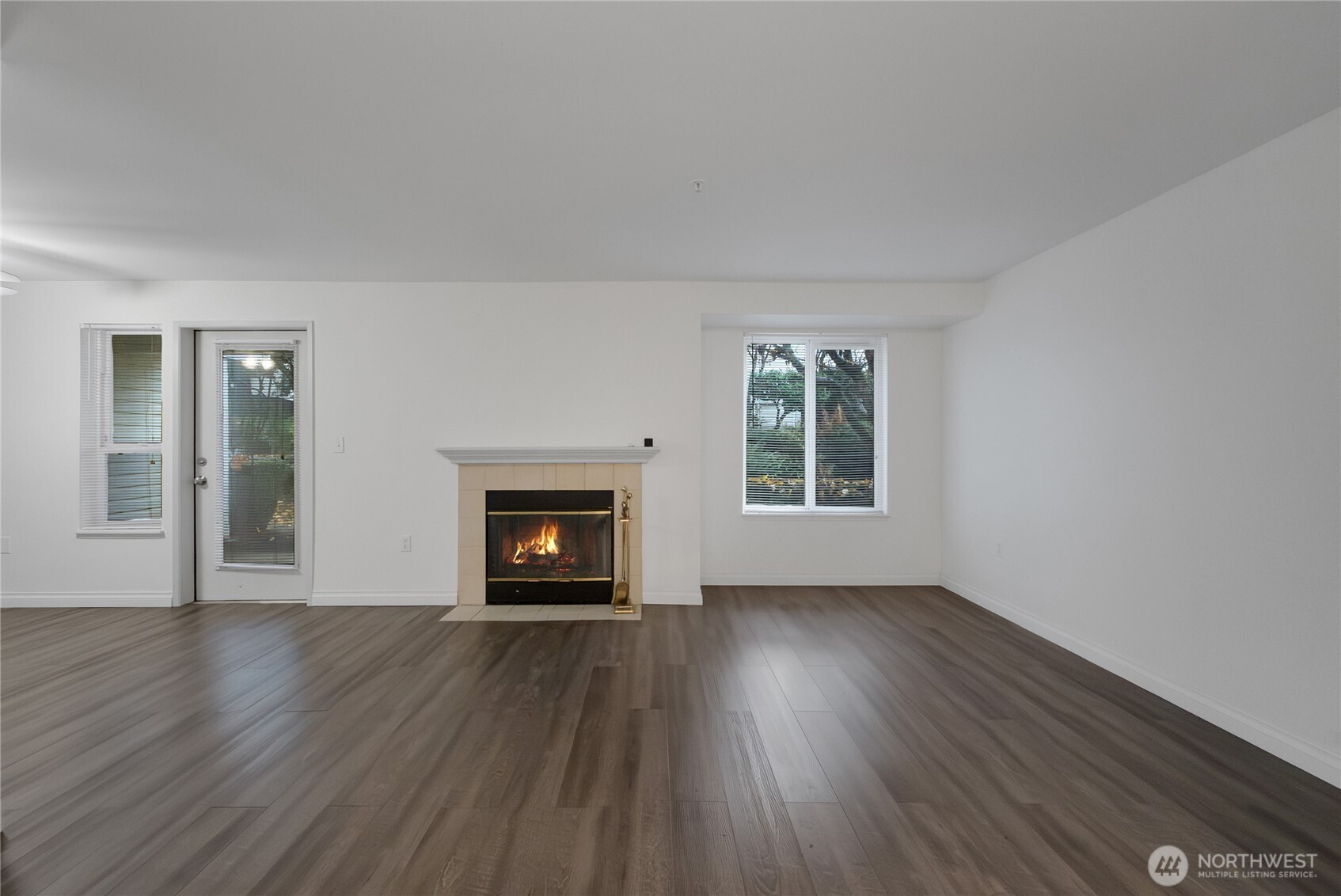 11002 Southeast Petrovitsky Road, Unit E103 Renton, WA 98055 - Photo 6 of 14 a view of an empty room with wooden floor fireplace and a window