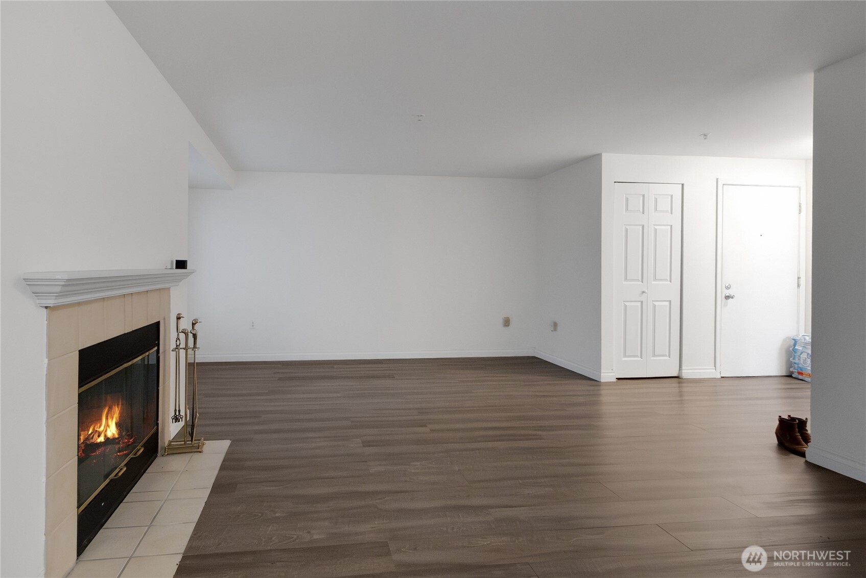11002 Southeast Petrovitsky Road, Unit E103 Renton, WA 98055 - Photo 7 of 14 a view of an empty room with wooden floor fireplace and a window
