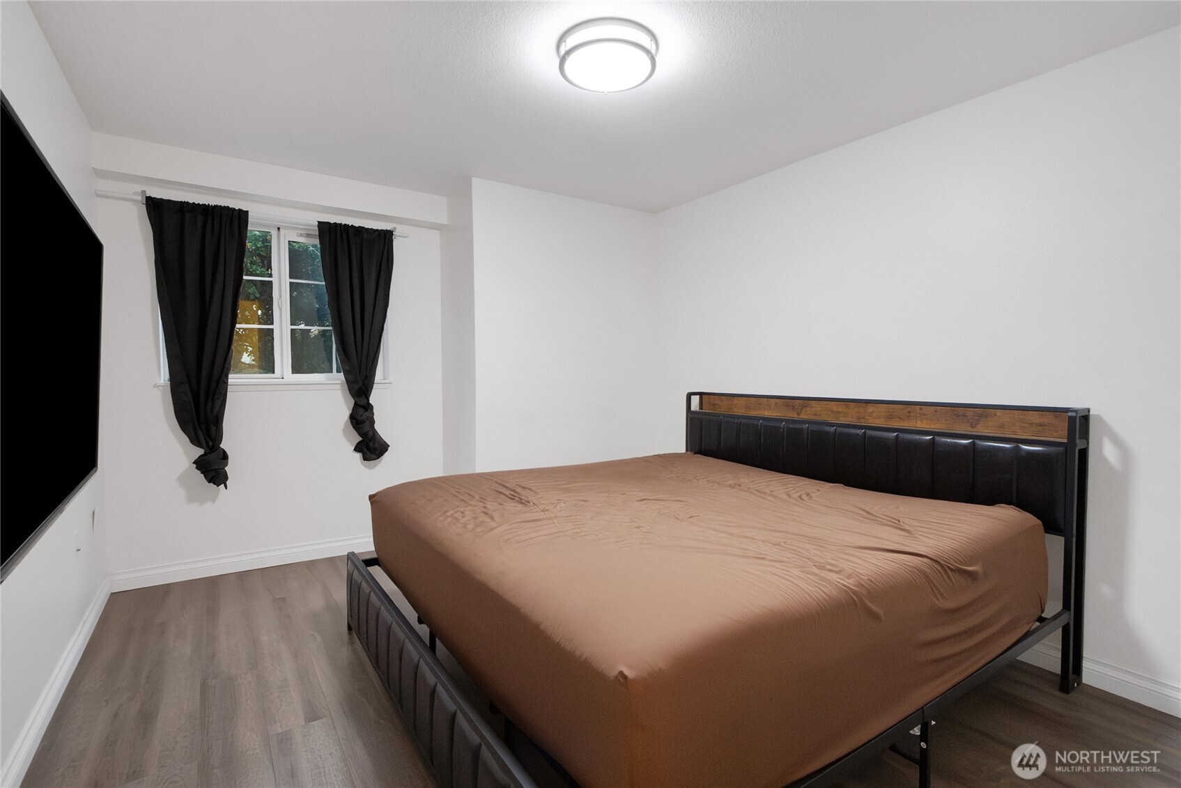 11002 Southeast Petrovitsky Road, Unit E103 Renton, WA 98055 - Photo 10 of 14 a bedroom with a bed and wooden floor