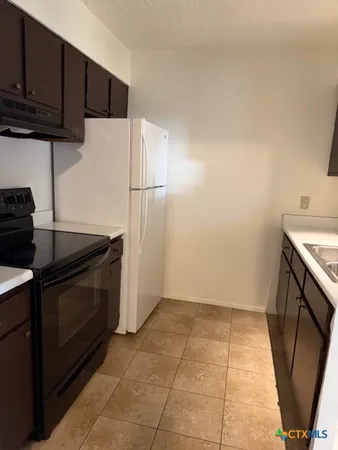 a kitchen with a sink a stove and cabinets