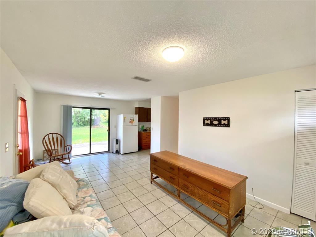 1423 Victory Palm Drive Edgewater, FL 32132 - Photo 6 of 11 a spacious bedroom with a bed and a couch