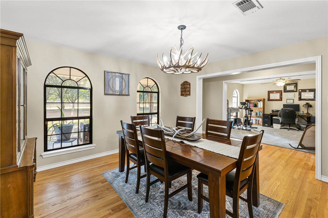 31928 Reids Prairie Road Waller, TX 77484 - Photo 15 of 43 Dining space with an office area, light wood-style floors, a chandelier, and a ceiling fan