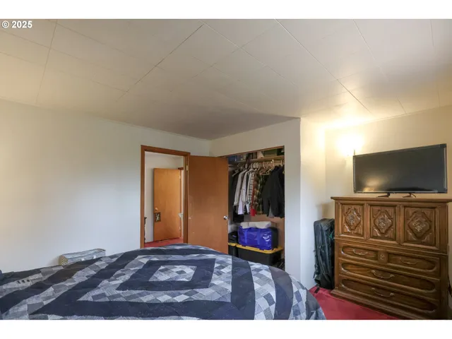 a bedroom with a bed and a flat screen tv