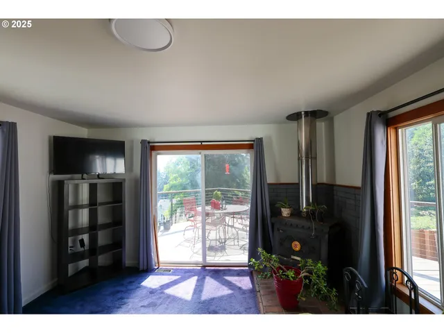 a living room with furniture a floor to ceiling window and wooden floor