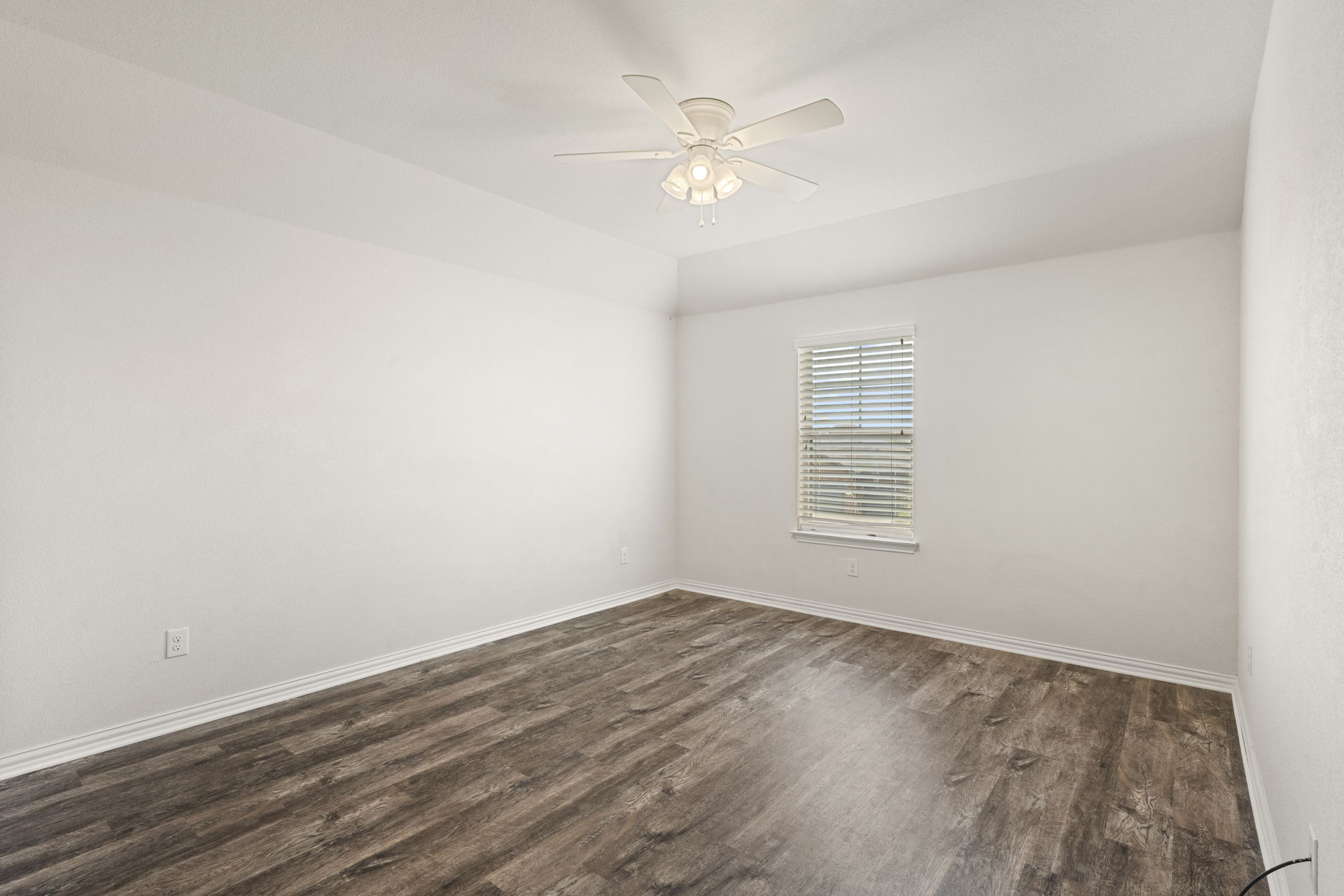 373 Rough Bark Street Buda, TX 78610 - Photo 19 of 39 LVP flooring and a ceiling fan create a comfortable, versatile bedroom space.