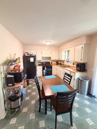 a view of a dining room with furniture and a kitchen view