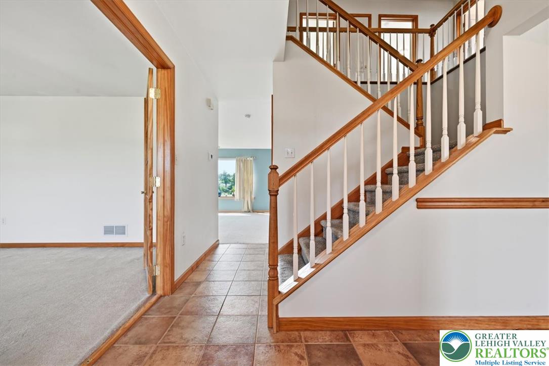 66 Labar Road Bangor, PA 18013 - Photo 5 of 56 A grand wooden staircase with white balusters anchors this bright and welcoming entryway, leading to sun-drenched rooms.