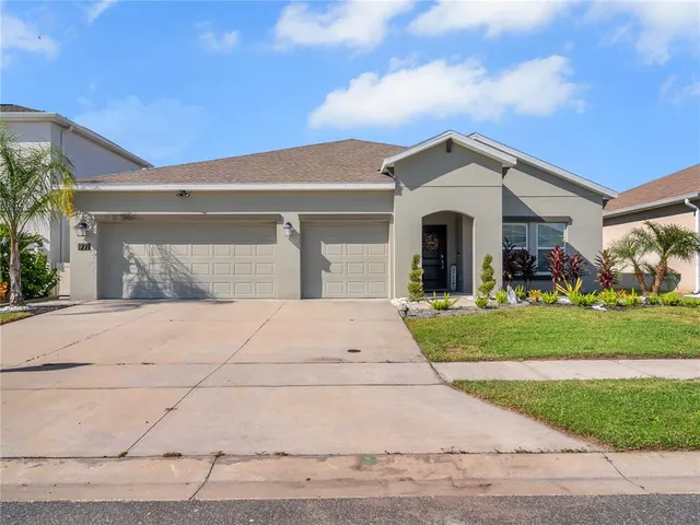 a front view of a house with garage and garden