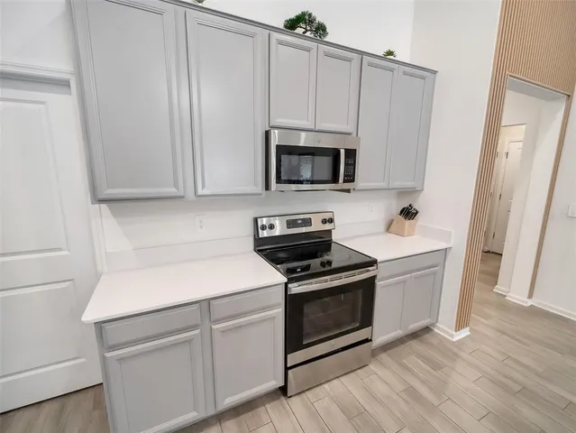 a kitchen with white cabinets and stainless steel appliances