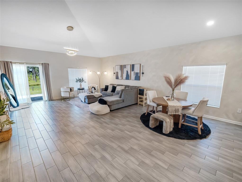 771 Hitch Loop St. Cloud, FL 34772 - Photo 13 of 34 a living room with furniture hard wood floor and a large window