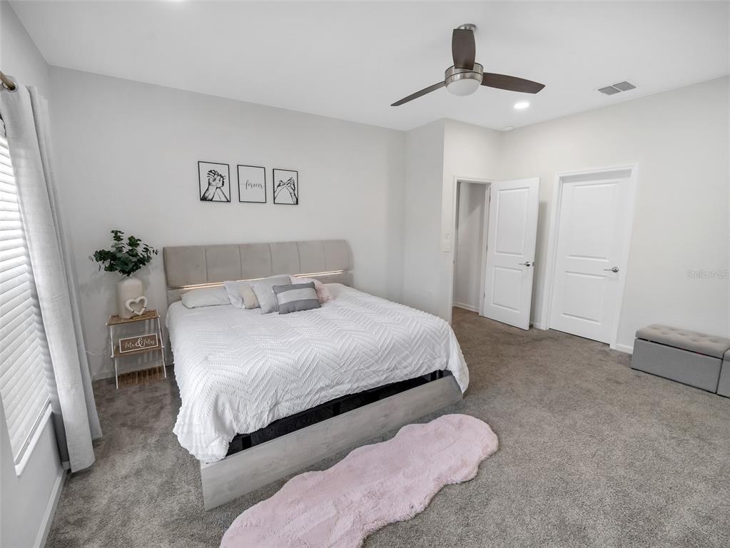 771 Hitch Loop St. Cloud, FL 34772 - Photo 22 of 34 a bedroom with a bed and a chandelier