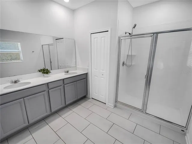 a bathroom with a double vanity sink mirror and shower