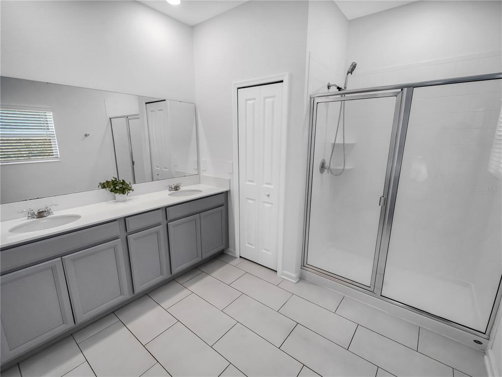 771 Hitch Loop St. Cloud, FL 34772 - Photo 24 of 34 a bathroom with a double vanity sink mirror and shower