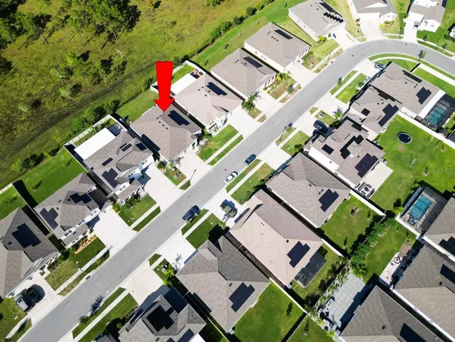 an aerial view of a house with a yard