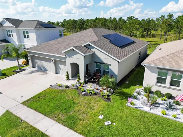 a aerial view of a house with table and chairs in a garden