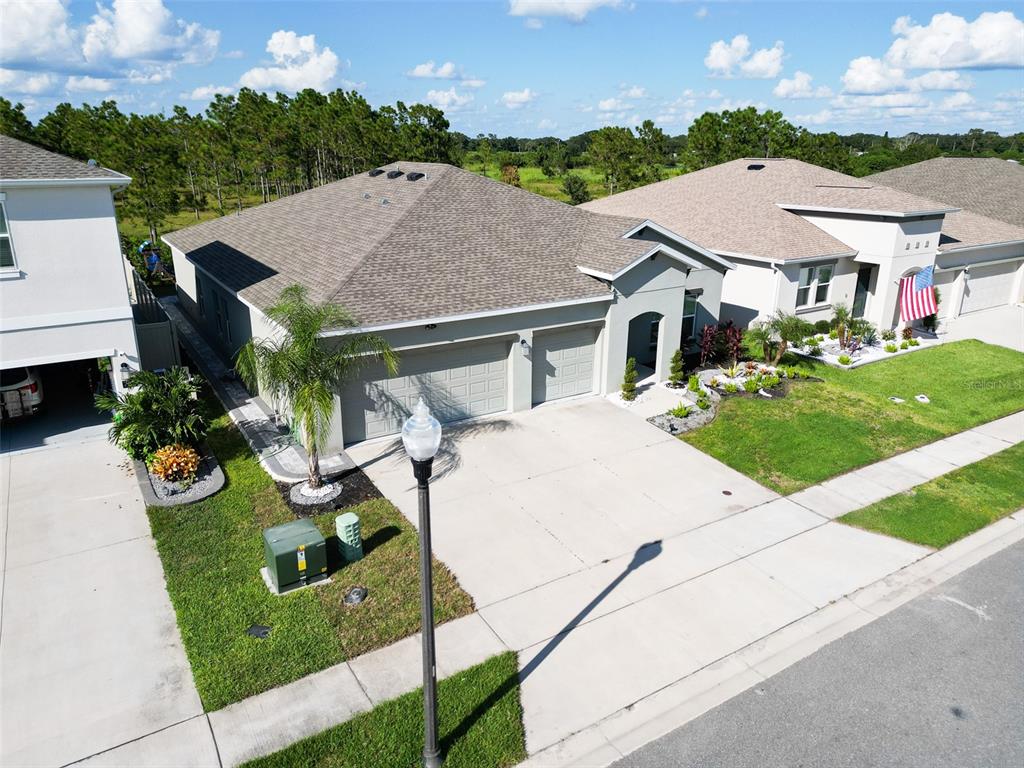 771 Hitch Loop St. Cloud, FL 34772 - Photo 4 of 34 a view of a white house with a yard plants and large tree