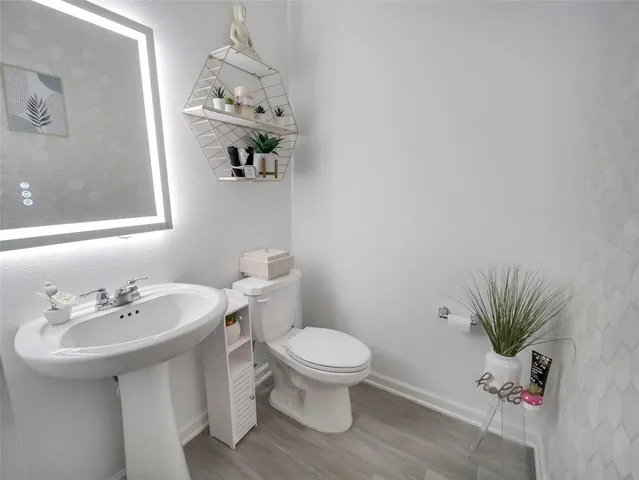 a bathroom with a sink a toilet and a mirror