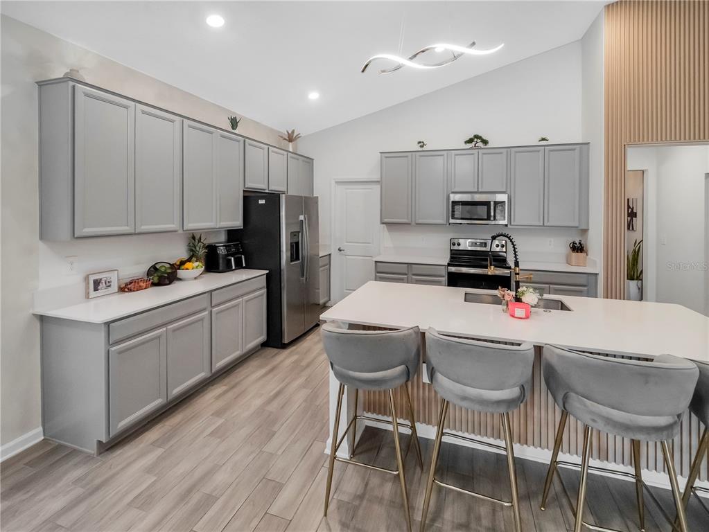 771 Hitch Loop St. Cloud, FL 34772 - Photo 9 of 34 a kitchen with stainless steel appliances a stove a sink a refrigerator cabinets and a table