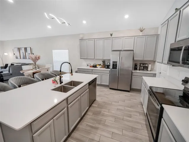 a kitchen with refrigerator a stove a sink cabinets and a counter top space