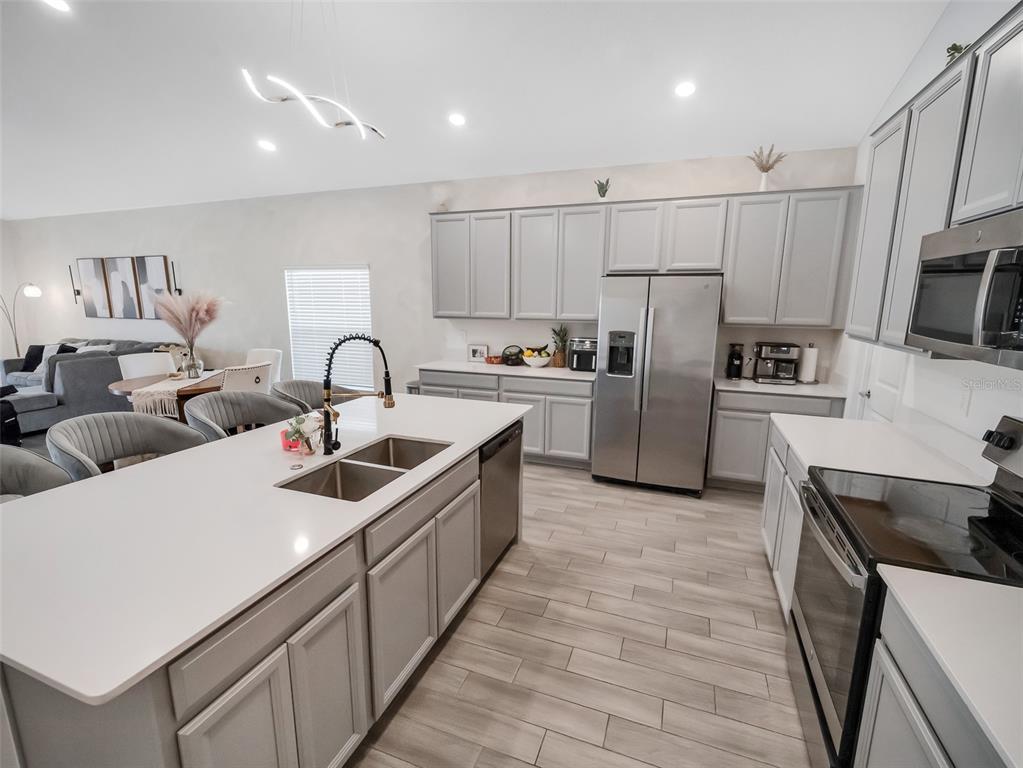 771 Hitch Loop St. Cloud, FL 34772 - Photo 10 of 34 a kitchen with refrigerator a stove a sink cabinets and a counter top space