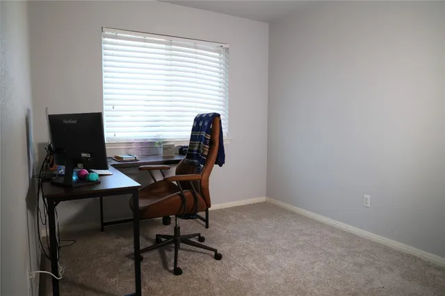 a view of a workspace with furniture and a window