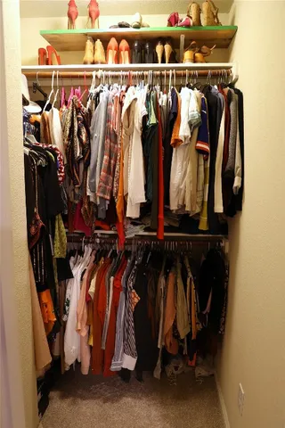 a view of walk in closet with clothes and shoes